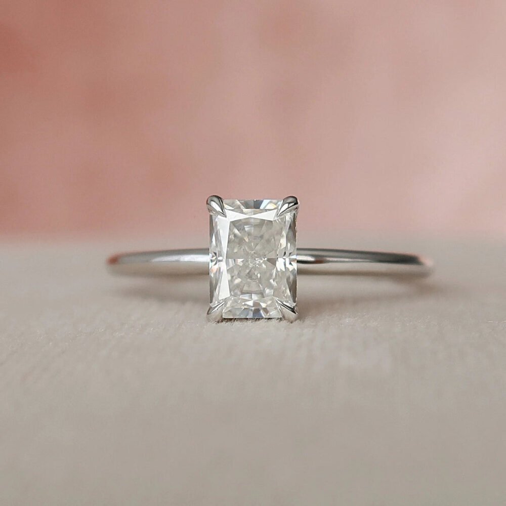 1ct elongated radiant cut moissanite engagement ring with hidden halo, paired with wedding band set for women.