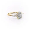 2 carat oval moissanite engagement ring worn on hand in yellow gold showing cluster side stones and slim band lifestyle view (1)_1