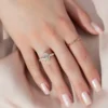 2 carat oval moissanite engagement ring worn on hand in yellow gold showing cluster side stones and slim band lifestyle view (2)