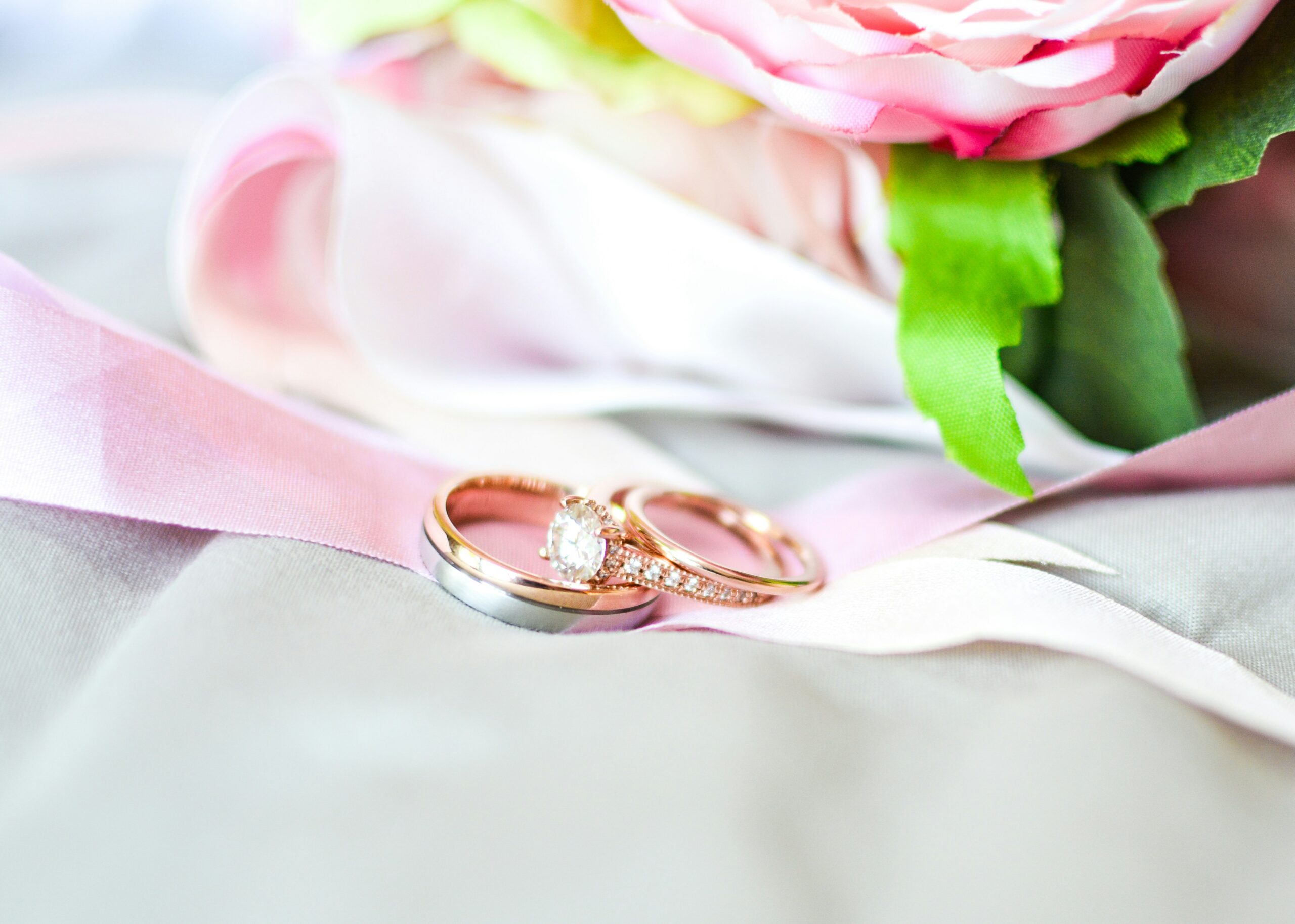 Moissanite Engagement Rings For Women silver-and-gold-colored rings near pink flower