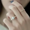 4 ct round diamond engagement ring held in fingers rose gold side view showing slim polished band and elevated claw basket