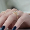 4 ct round diamond engagement ring held in fingers rose gold side view showing slim polished band and elevated claw basket