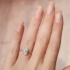 The Seraphina | Hidden Halo Oval Moissanite Engagement Ring A beautiful 14K white gold hidden halo oval moissanite engagement ring on a finger