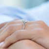 The Seraphina | Hidden Halo Oval Moissanite Engagement Ring A beautiful 14K white gold hidden halo oval moissanite engagement ring on a finger