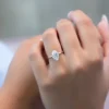 The Seraphina | Hidden Halo Oval Moissanite Engagement Ring A beautiful 14K white gold hidden halo oval moissanite engagement ring on a finger