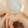 The Seraphina | Hidden Halo Oval Moissanite Engagement Ring A beautiful 14K white gold hidden halo oval moissanite engagement ring on a finger
