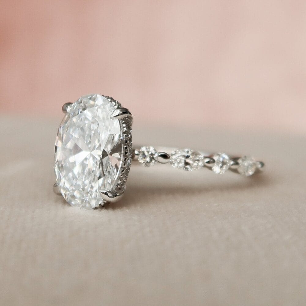 Oval Engagement Ring with Wedding Band Set A close-up of a 2.0CT oval cut moissanite halo eternity bridal engagement ring. The ring features a large oval center stone surrounded by diamond