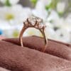 A rose gold cushion cut engagement ring featuring three sparkling diamonds, symbolizing love and commitment.