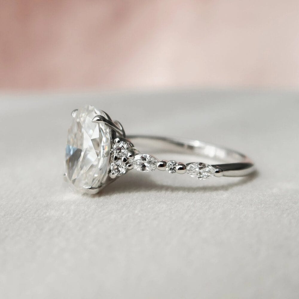 A vintage oval wedding rings sets with a diamond-studded band, featuring a marquise-shaped diamond accent.