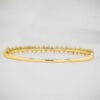 Adorn yourself with this elegant 14K Gold Bangle Bracelet, featuring tapered baguette moissanite stones. A timeless piece from our Classic Jewels collection.