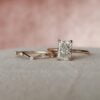 Bridal set featuring 2 carat radiant cut moissanite engagement ring with hidden halo in 14K rose gold.