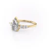 Moissanite pear cut wedding ring with cluster side stones displayed against white background