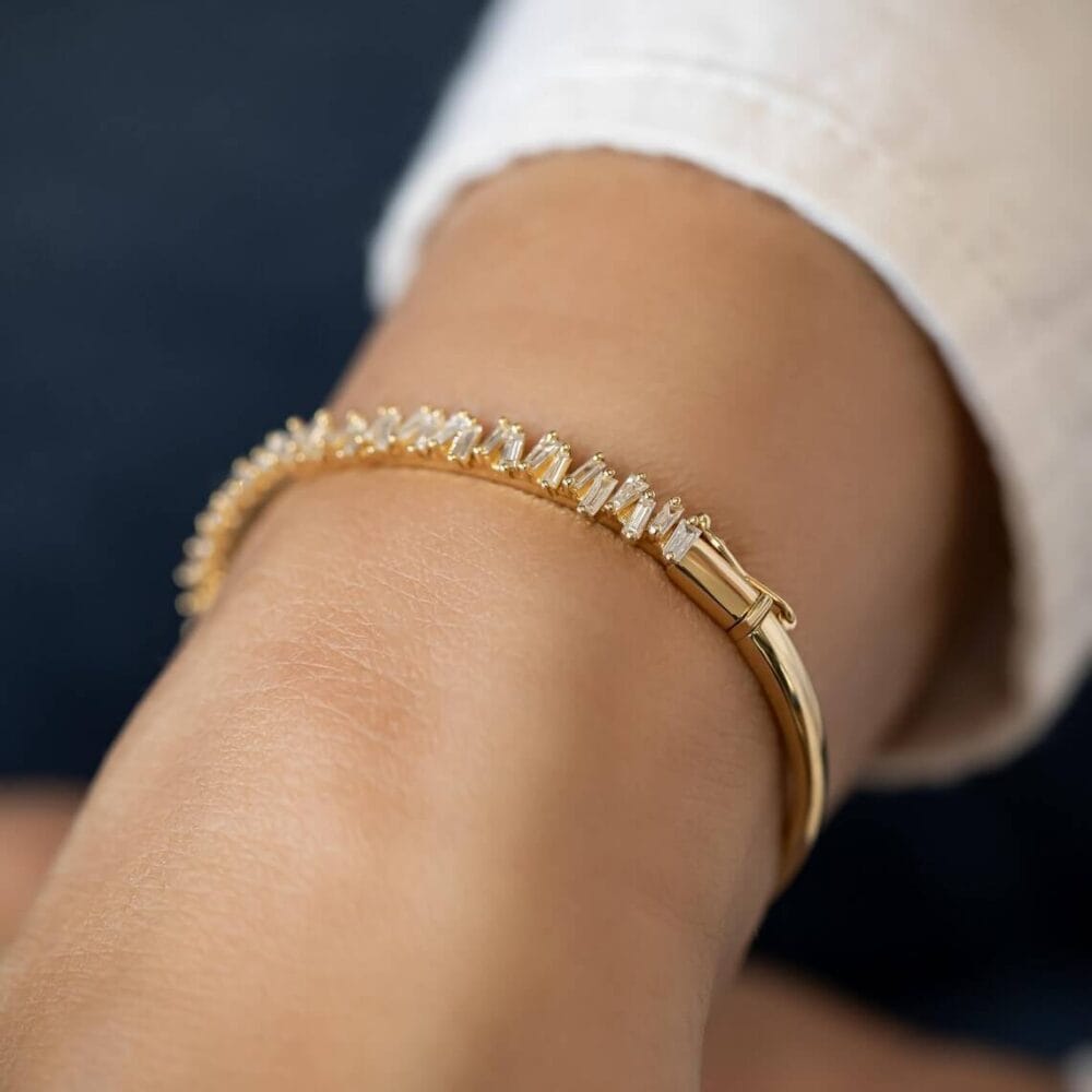 This Tapered Baguette Moissanite Bangle Bracelet, crafted in 14K gold, showcases classic sophistication and luxurious brilliance, making it perfect for any jewelry