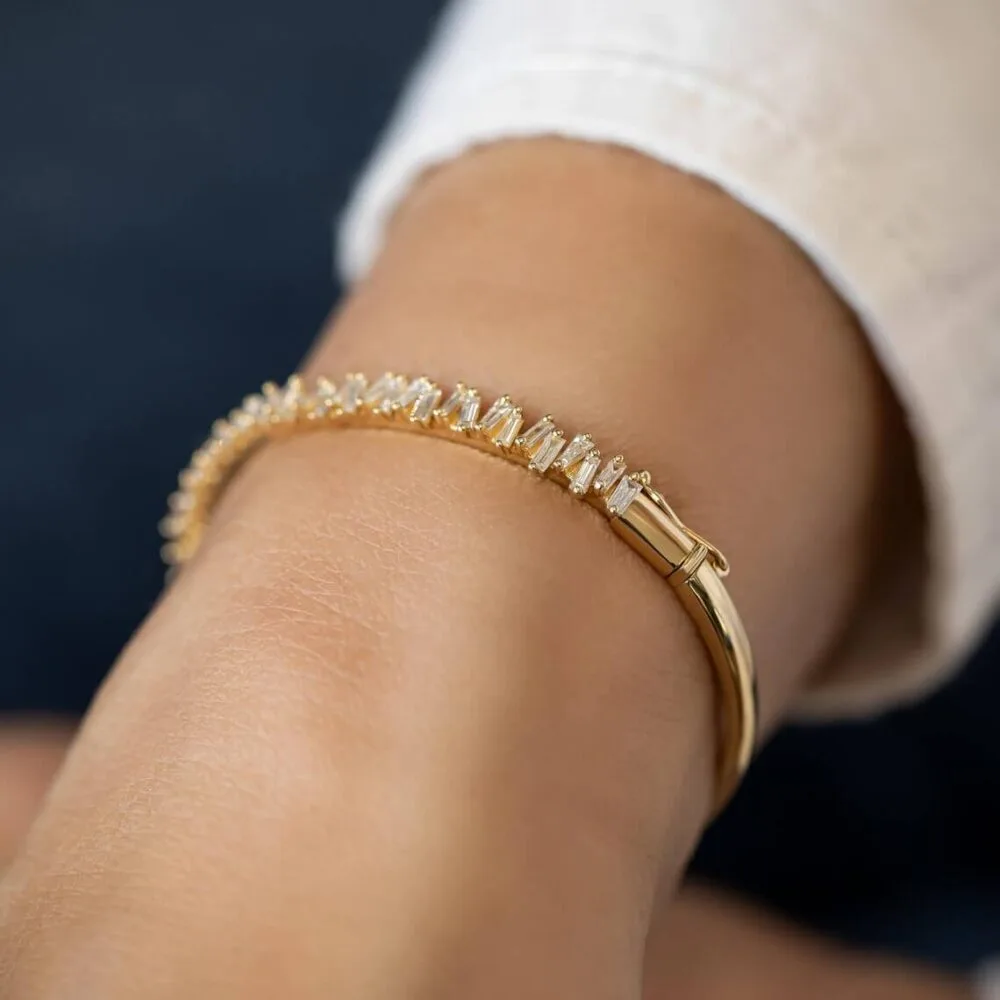 This Tapered Baguette Moissanite Bangle Bracelet, crafted in 14K gold, showcases classic sophistication and luxurious brilliance, making it perfect for any jewelry