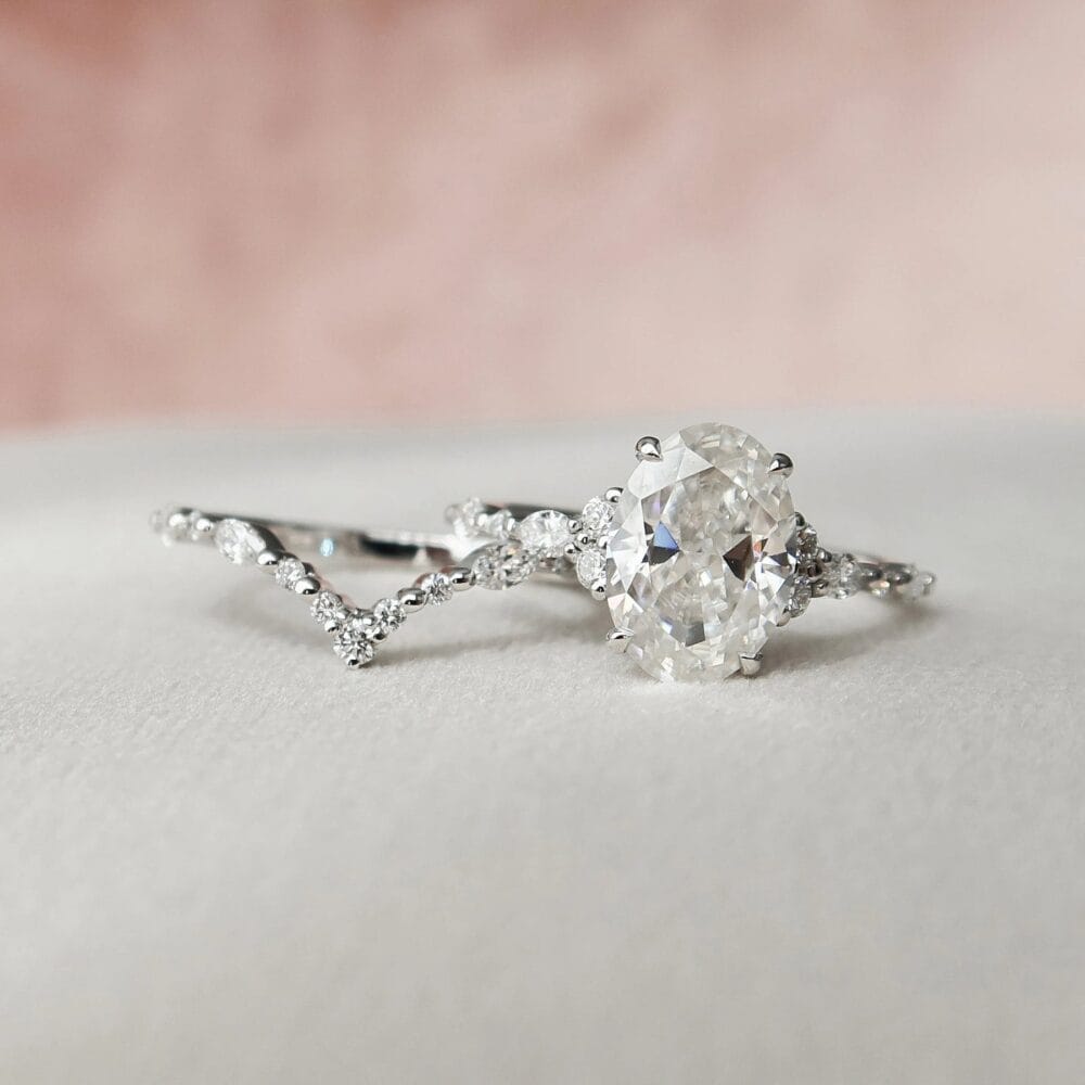 Vintage oval wedding rings sets with a chevron-shaped band, featuring sparkling diamonds.