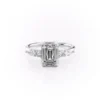 White gold classic emerald cut engagement rings side profile showing staggered pear and round side stone cluster
