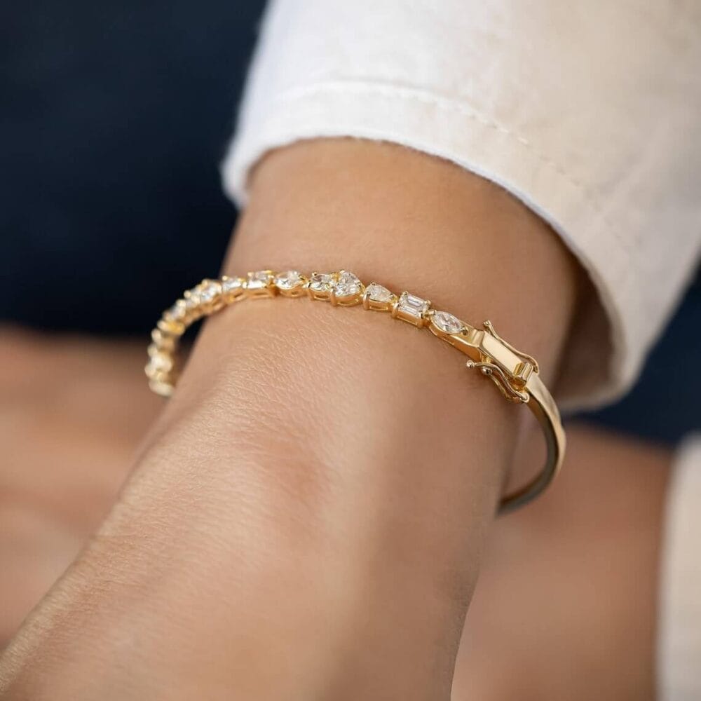 this stunning bangle bracelet features 2.2Ct of multi-shaped moissanite diamonds set in 14K solid gold, offering a unique, luxurious design perfect for special moment