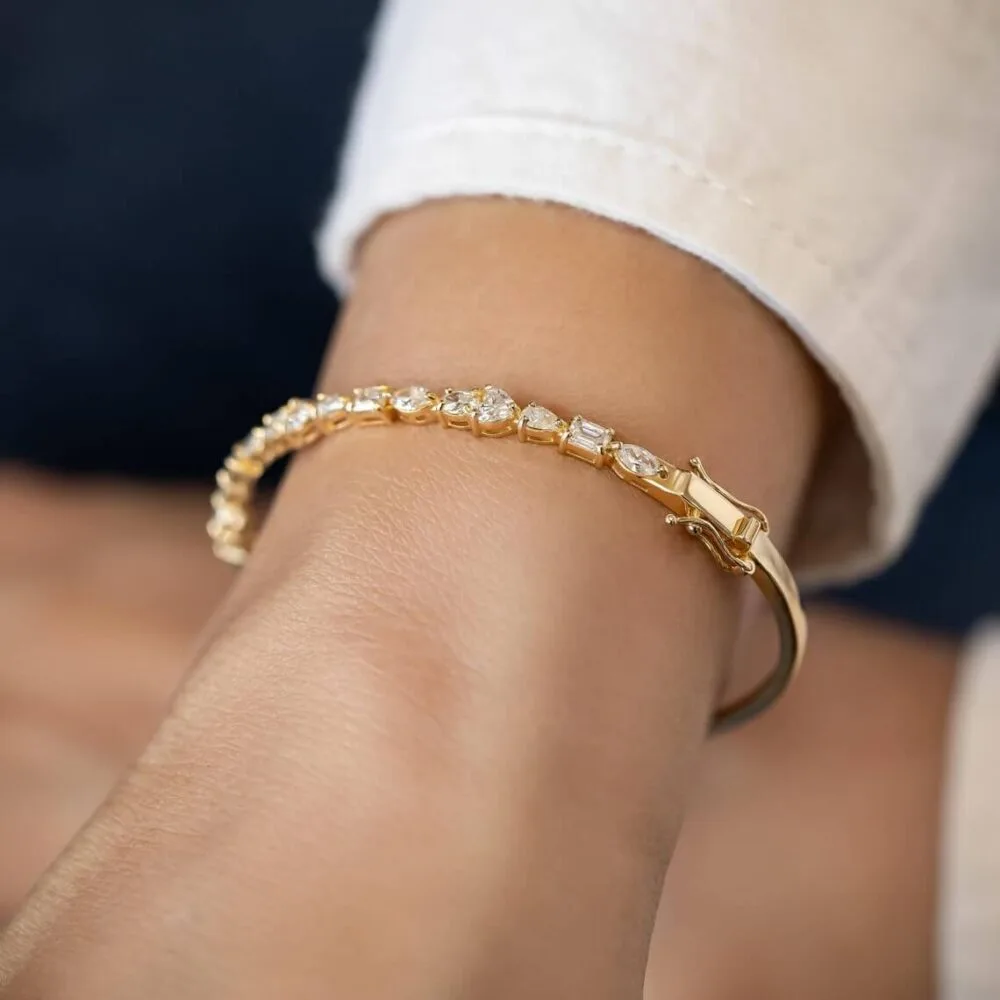 this stunning bangle bracelet features 2.2Ct of multi-shaped moissanite diamonds set in 14K solid gold, offering a unique, luxurious design perfect for special moment